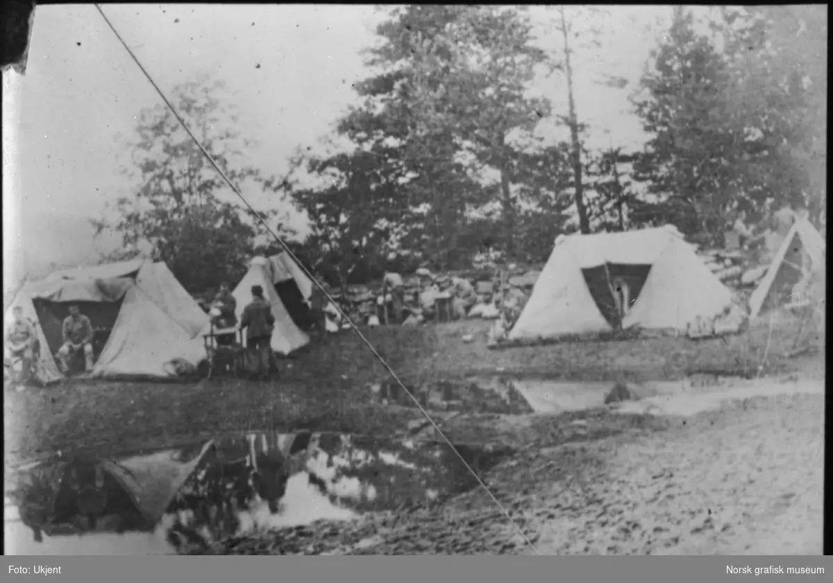 Soldater slapper av i en teltleir, antageligvis i området mellom Kongsvinger og Skotterud.
