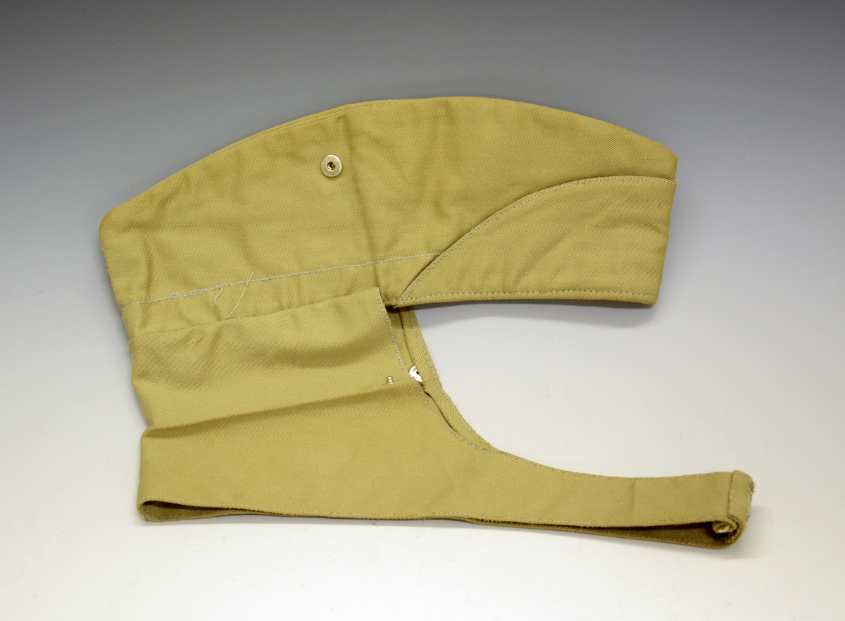 A.Uniformsjakke. Tropeuniform. Beige jakke i syntetisk materiale med 4 lommer foran. 8 knapper med emblem, skulderklaffene med rødt merke uten distinksjoner. Påsydd flygersymbolmerke foran. Jakken har fôr i armene og ved nakkepartiet. Belte med beltespenne.

B. Uniformslue. Luen har en brett festet med trykk-knapp på begge sider. Denne bretten kan brettes ut, og det blir en lue som kan festes under haken med to små knapper med emblem. Innvendig er det svettebånd og fôr.