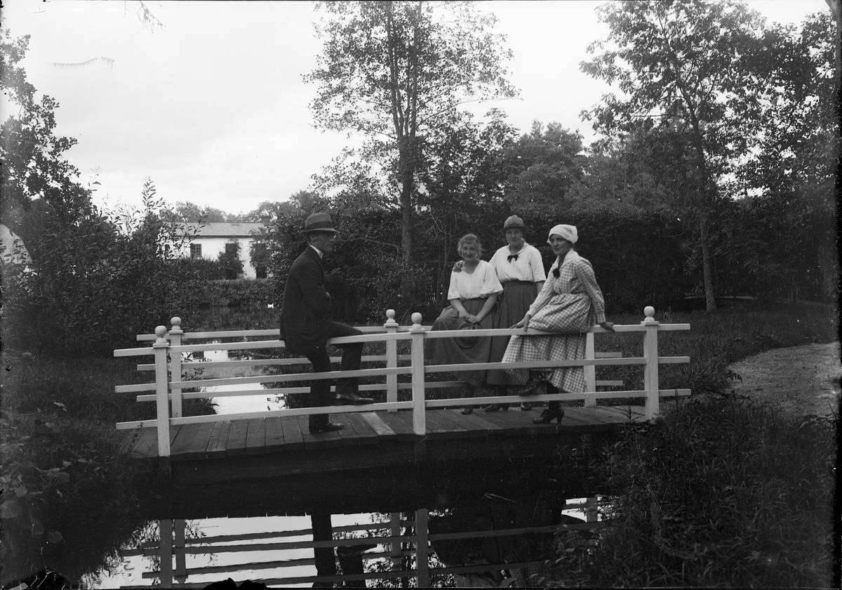 En man och tre kvinnor på liten bro, Engelska parken, Forsmark, Uppland