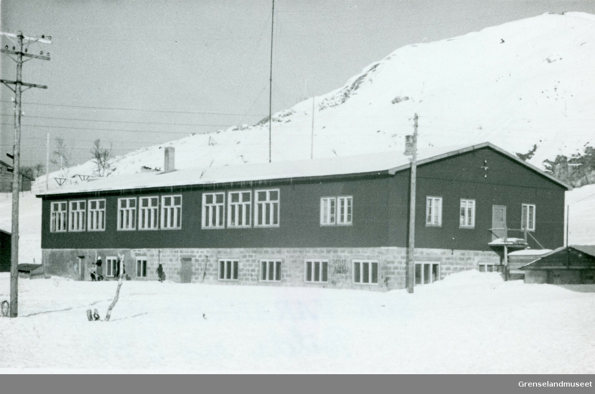 Realskolen i Kirkenes etter krigen 1946-1956. Brakka hadde fire klasserom. Vinduene til høyre er rektorboligen. Bildet er tatt i 1949. 