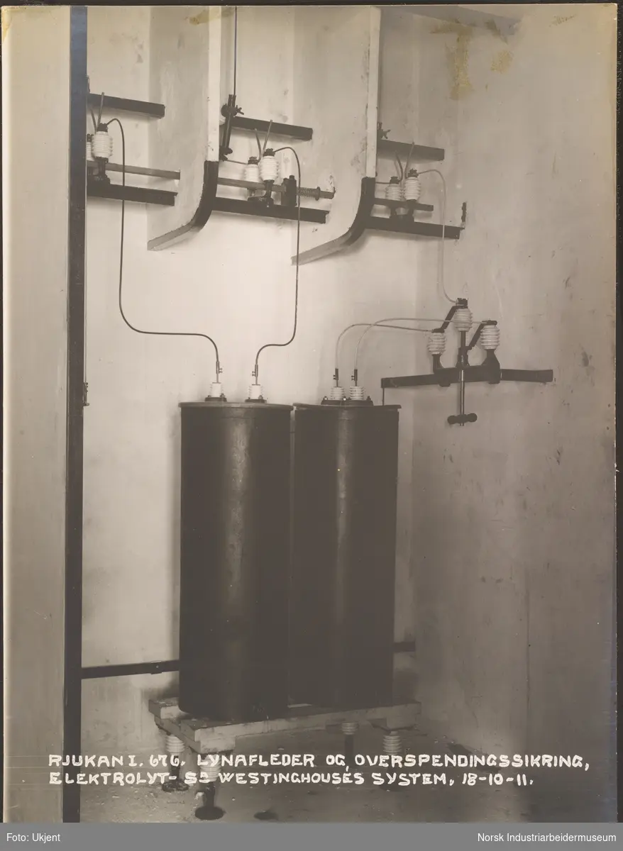 Plassering av lynavleder og overspenningssikring i lynavlederhuset (tårnet) på Vemork kraftstasjon. To runde kolber med ledninger koblet opp til vegg.