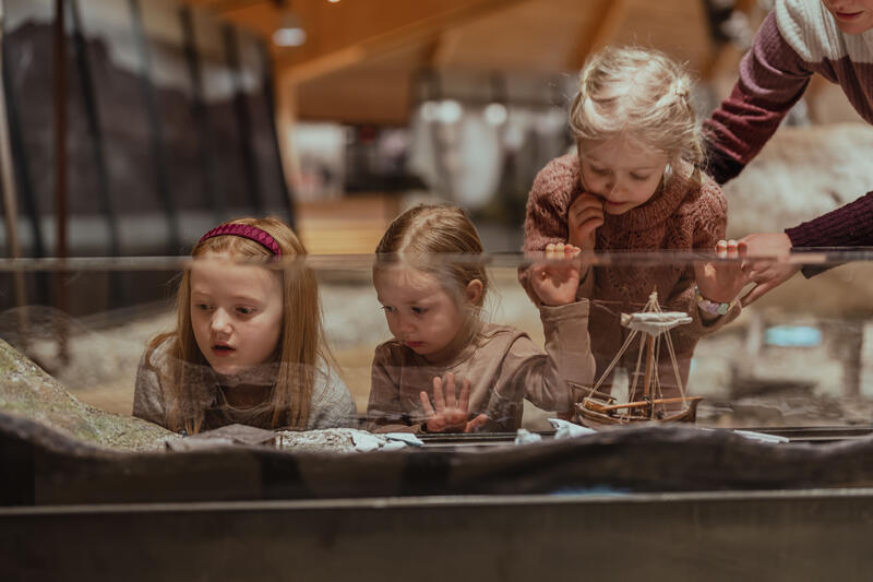 The photo shows children studying details in the museum.