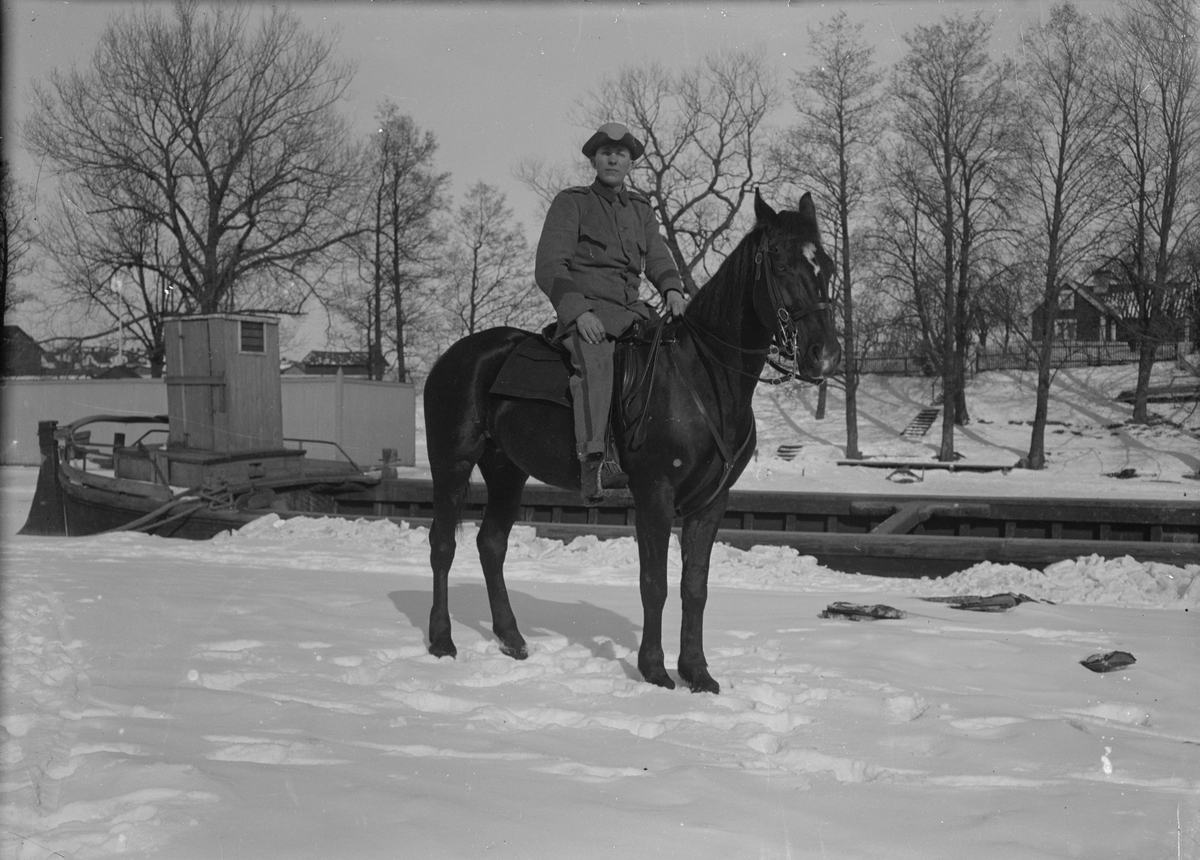 En armésoldat sitter till häst vid Stångån / Kinda kanal, vintertid, omkring 1914. Ryttaren tillhör antagligen I 4 eller I 5 regemente.