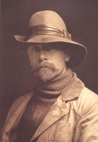 Edward S. Curtis, self-portrait 1899. Image of Curtis wearing late 1800s clothing, he has a mustache and beard, and he is wearing a hat.