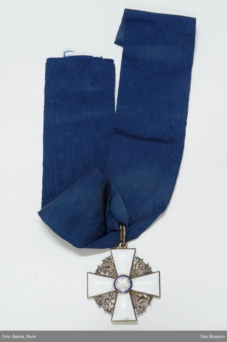 Ordenskorset er et hvitemaljert georgskors i gull, og bæres i et mørkeblått, vatret bånd.