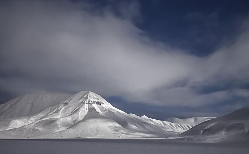 The photo shows Hiorthfjellet mountain under the moon.