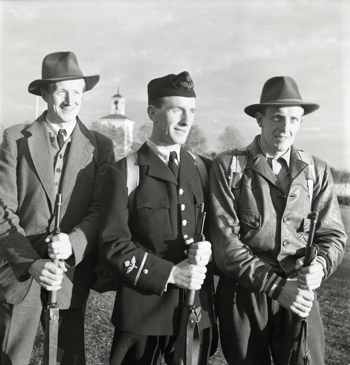 Tre män poserar med sina gevär efter distriktsmästerskapen i orieneringsskytte vid Segersta den 28 oktober 1951.