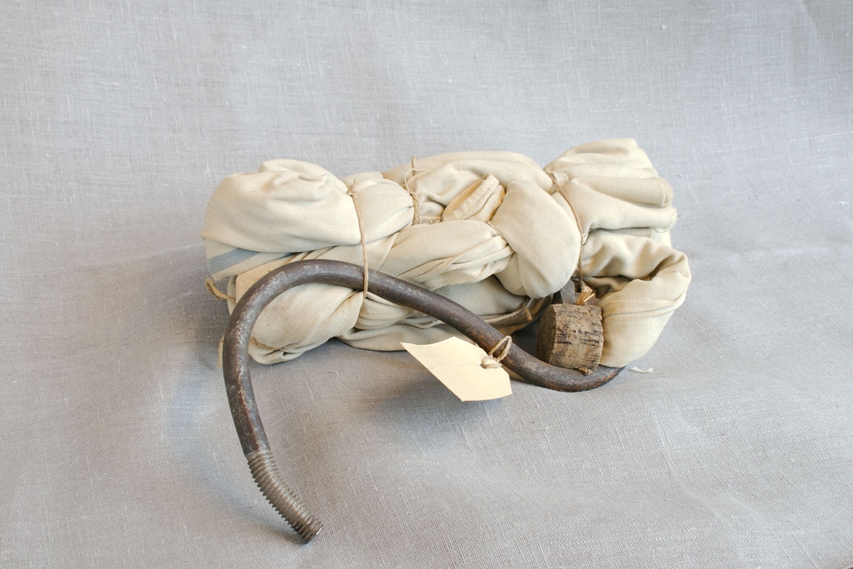 Tau laget av hvit tekstil med en kraftig krok i enden. Kroken er laget av en lang skrue.