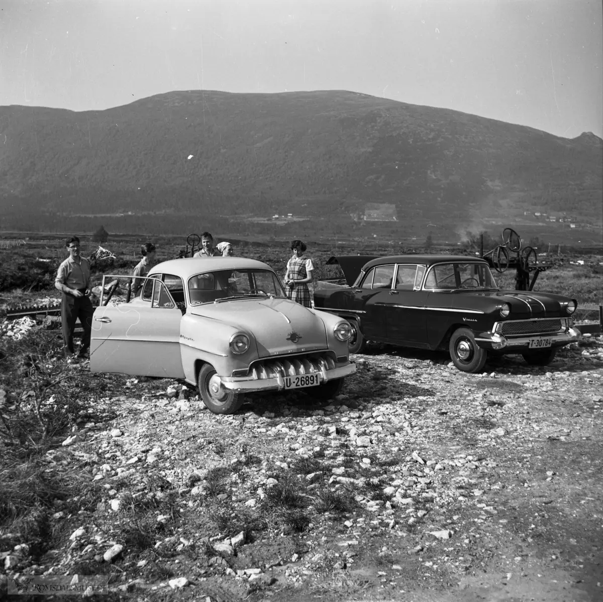 Frå Skjelvika, Eide. I bakgrunnen Krakalia, Stortua (heilt t.h.) og Vardhaugan bak..Bilene fra venstre: Opel Rekord 1953-54, Vauxhall Victor 1957-59.