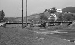 Tømmer i elva, bro, gårder. Slattum bro, Nitleva. Juni 1959.