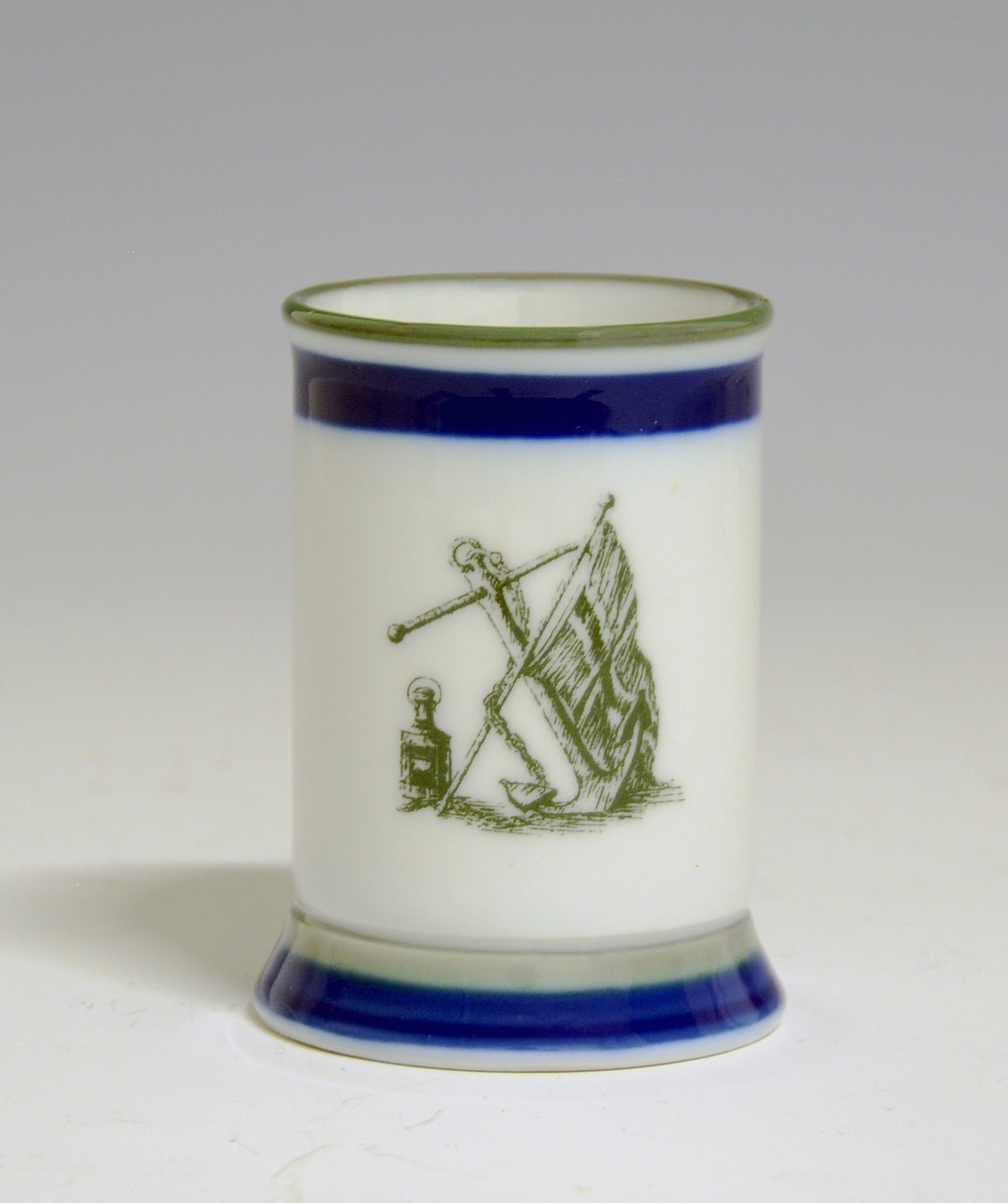 Drammeglass av porselen med motiv av anker og det norske flagget. Påskriften: Skomvær.