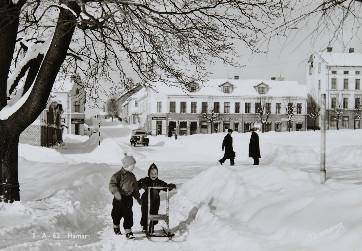 Postkort, Hamar by, Stortorget, Strandgata, vinter, barn med sparkstøtting, Åsgården i bakgrunnen med Kafe Nor,