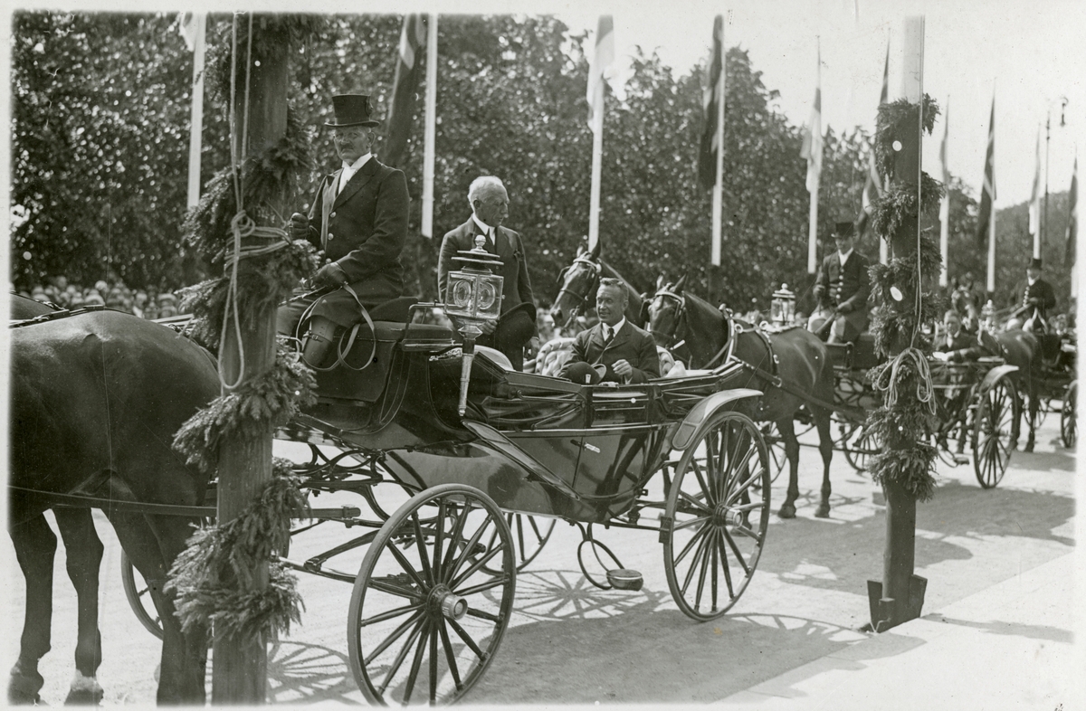 Roald Amundsen står oppreist i landauer med kusk og en annen person sittende (Bilde 2) - Roald Amundsens ankomst til Oslo med N25 - 4. juli 1925