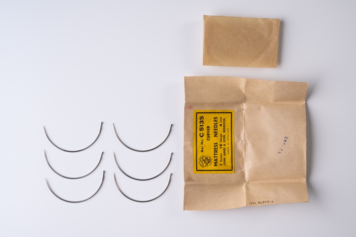 Madrassnålar, 6 st, i pappersförpackning. Förpackningen innehåller böjda nålar av metall med konformad spets och ovalt öga.

Förpackningen består av ett beige omslagspapper och ett inre vaxat papper (något skadade). På omslagspapperet sitter en gul pappersetikett: ”SERPENT BRAND TRADE MARK ART No C5135 CURVED MATTRESS NEEDLES 1 Dozen Gauge 16 4 Inch JOHN JAMES & SONS, REDDITCH. MADE IN ENGLAND”. På papperet är stämplat: "53 [?]65".

Se vidare Historik.