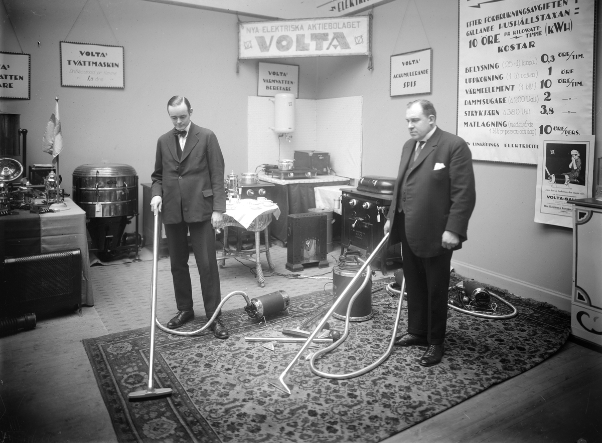 Nya Elektriska AB demonstrerar förträffligheten med dammsugaren Volta. Från utställning omkring 1930, sannolikt i Linköping.