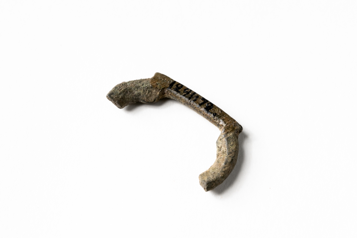 Fragment av en sölja. Rak form nertill med antydan till rundare form på sidorna.