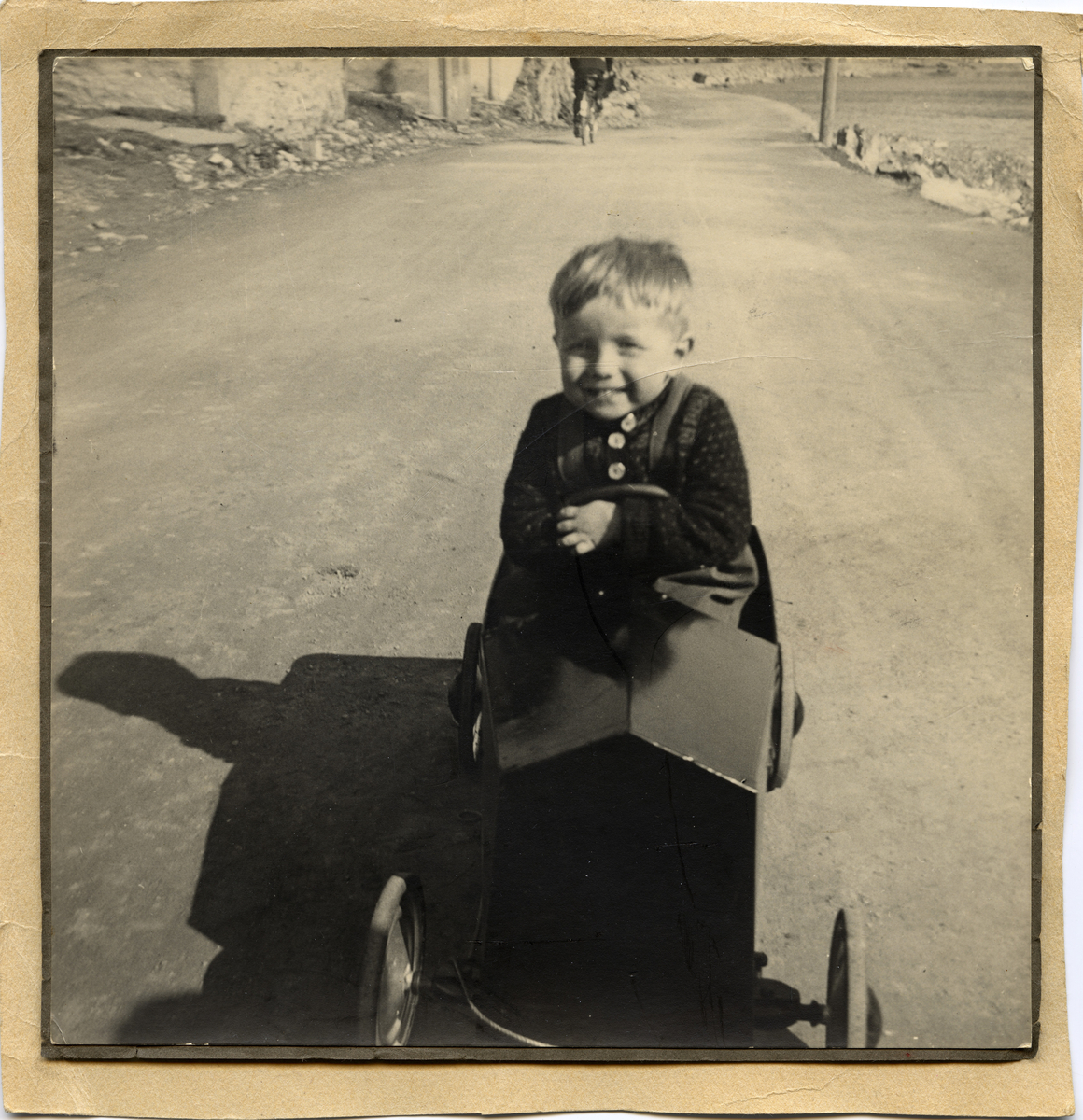 Femåringen Jan-Egil smiler stort mens han kjærer sin tråbil på Fuglenesveien i 1944.