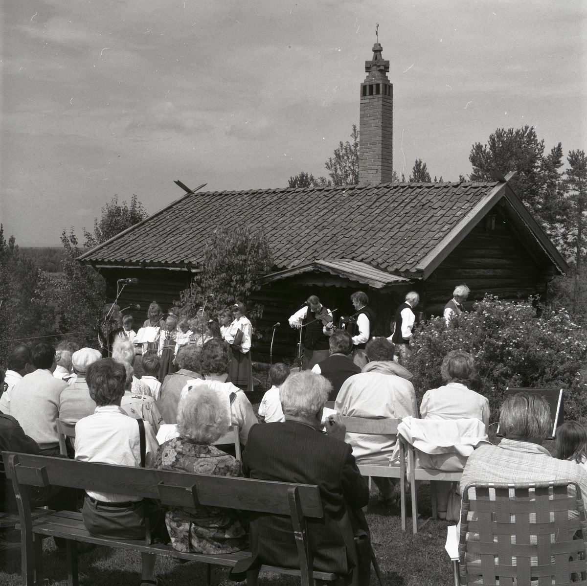 En kör och några spelmän underhåller publiken vid Lärkadagen på Sollerön den 21 juli 1990.