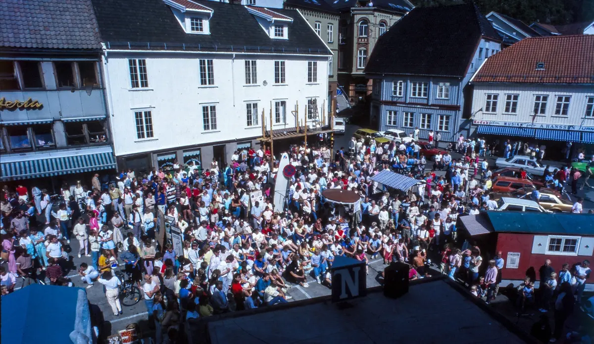 Foto av et tettpakket torg i Kragerø, der alle har møtt opp for å bli tegnet av Odd Einarson