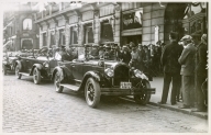 Åpne biler står klar til å motta passasjerer til bilkortesje utenfor Grand Hotel, omgitt av mange tilskuere - Roald Amundsens ankomst til Oslo med S/S "Bergensfjord" efter "Norge"s færden over Polen - 16. juli 1926.