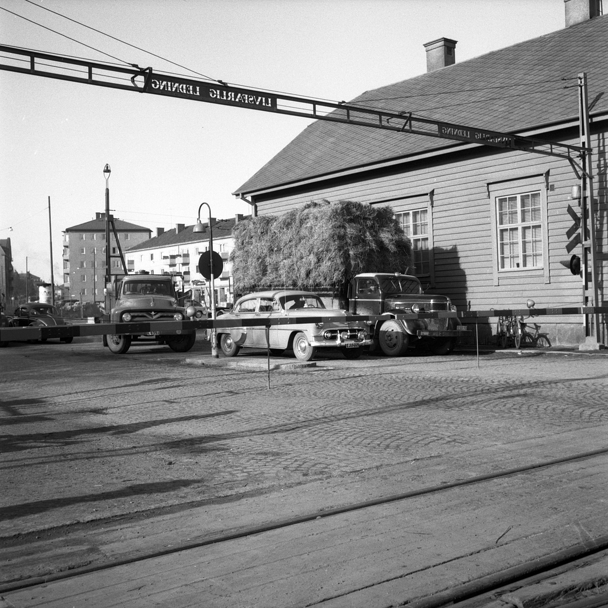 Köbildning vid järnvägsövergången invid korsningen av Industrigatan-Oskarsgatan i Linköping. Närmast till höger ligger SJ:s godsmagasin och i bakgrunden ses bebyggelsen utmed Gustav Adolfsgatan i Vasastaden.