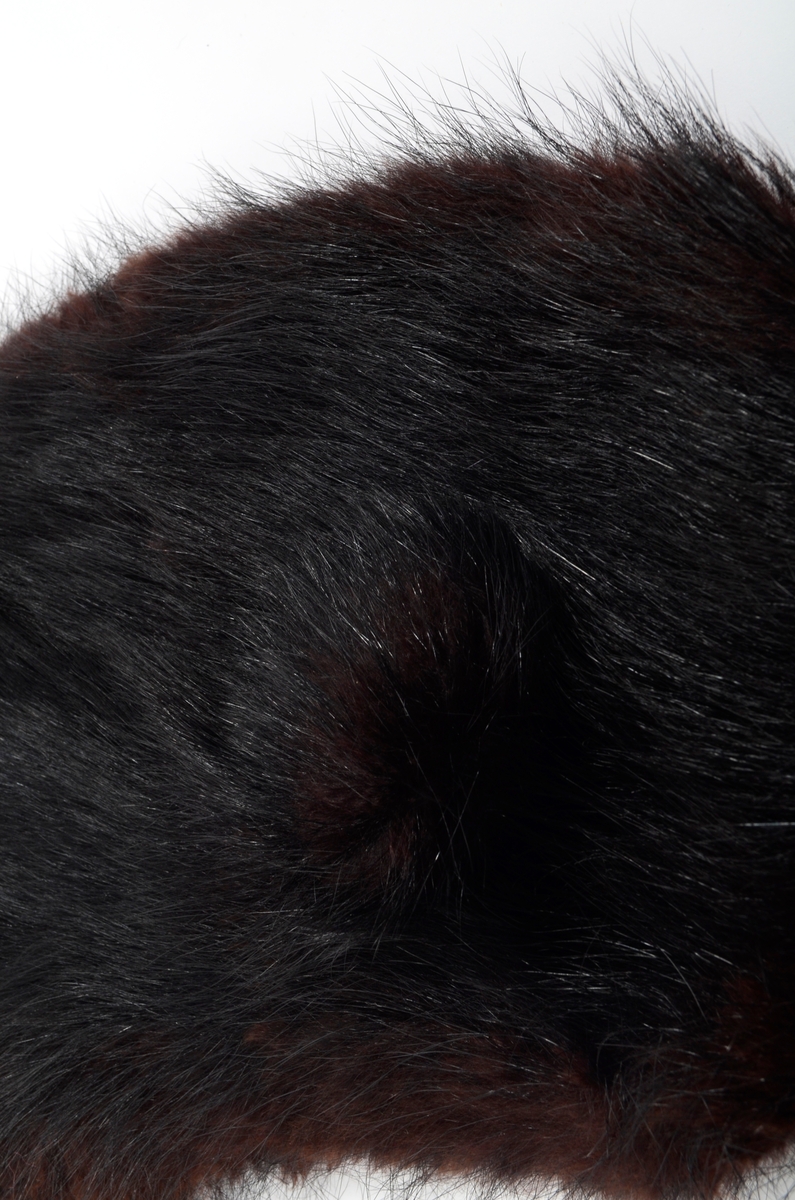 Løs, buet krage i brunsvart pels fôret med svart silkestoff.
