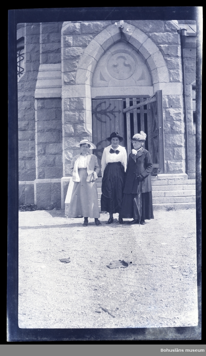 Tre personer framför ingången till en kyrka.