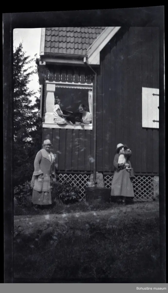 Två personer ståendes på en veranda med en bok i händerna. Två personer ...