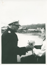 Kong Olav mottar blomster.