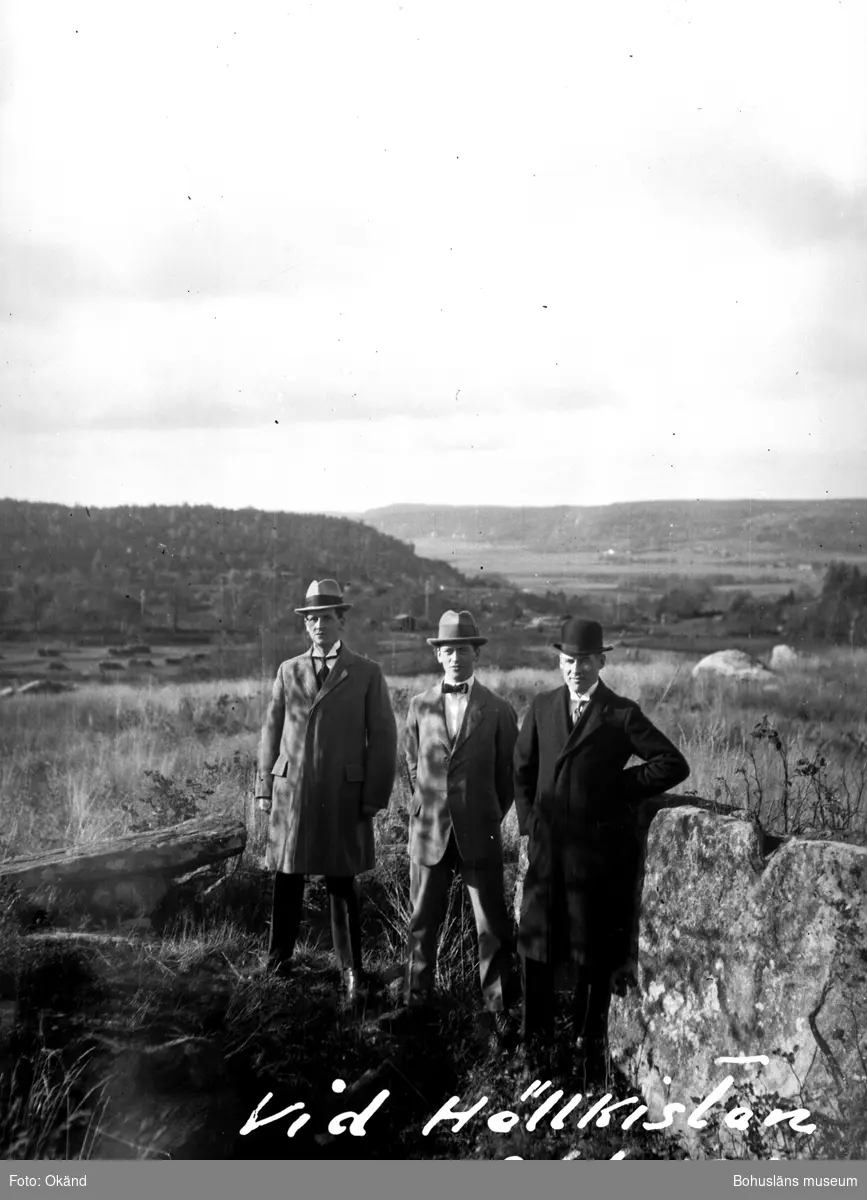 Tre personer ståendes vid en hällkista. Enligt notering på negativet: "Vid Hällkistan okt. 1920".