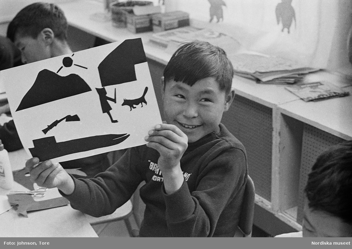Arktis. Lappland. En flicka gör en teckning i skolan. En pojke håller en teckning.