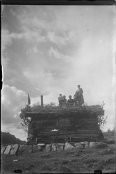Kvinner og barn stående på taket av hytta kalt "Hygga" i Fjø