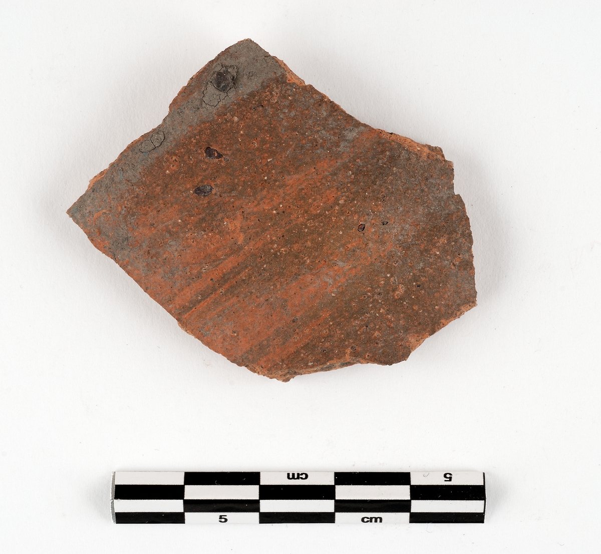 Del av kärl. Keramik. Nästan stengods (C1). Kanna. Orange utan engobe. Datering: cirka 1250-1350. Rhenländsk import.