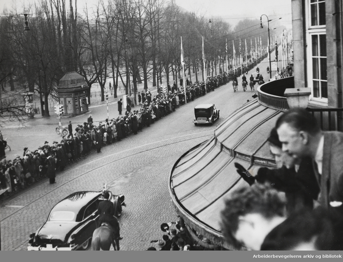 Kong Gustav VI Adolf besøker Oslo. Mars 1952. Bilkortesjen på Karl Johan sett fra Grand Hotel.