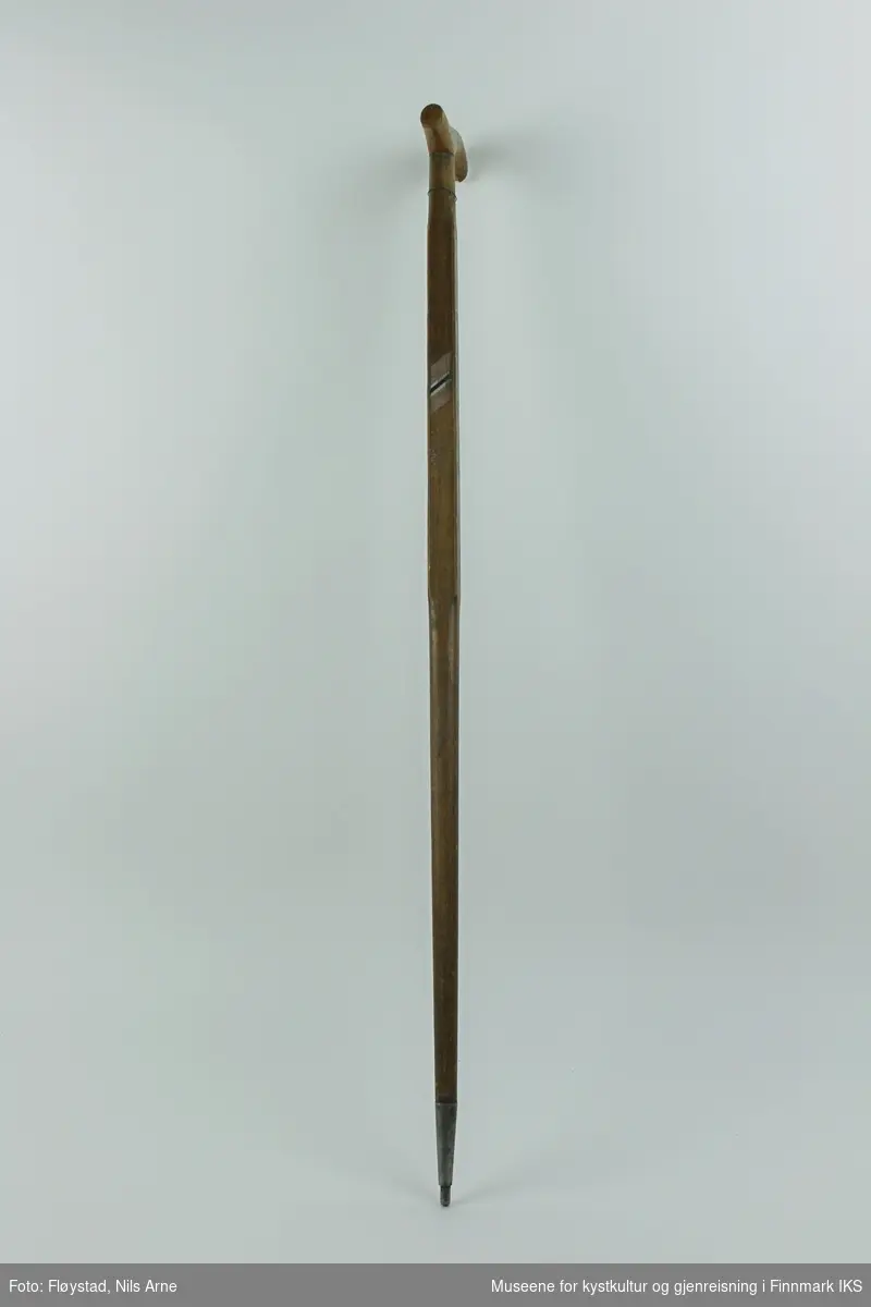 En trestokk med doppsko av stål i enden og med buet håndtak. Stokken er lakkert og dekorert med en påmalt flaggstripe av det norske flagg i rødt, hvitt og blått.og "Nordkapp" skrevet i hvitt på den ene siden av stokken. 