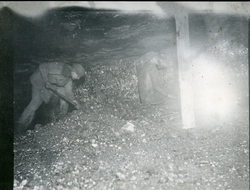 To menn (muligens Bay og Sandnæs) på arbeid inne i en gruve 
