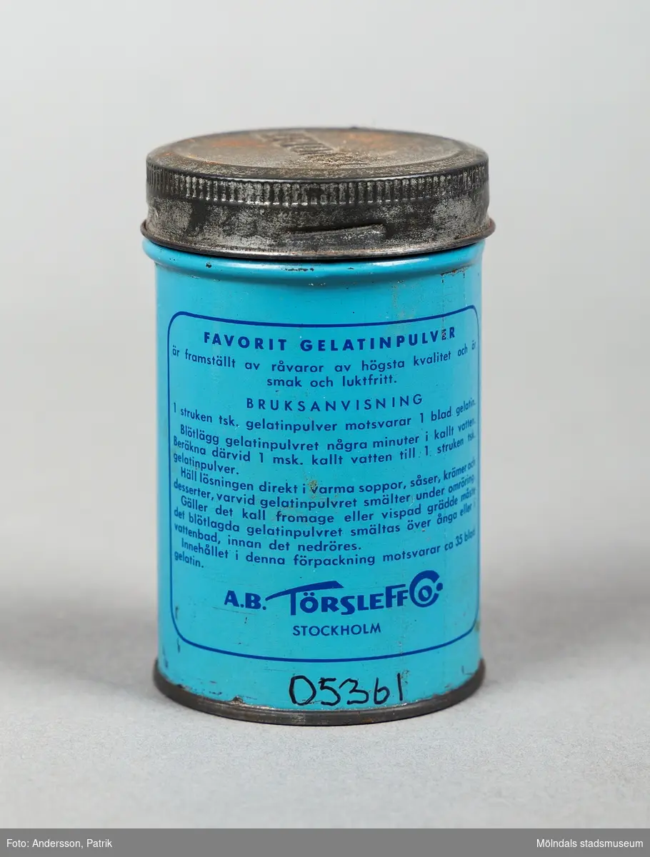 En mellanblå plåtburk med ett silverfärgat lock som innehållit gelatin pulver. Det står Extra Guld med skrivstil längst upp på framsidan. Därunder står det Favorit Gelatin med versaler med blå text. 
En silverfärgad fjäril pryder burken under bokstäverna.
Text på baksidan:
Favorit gelatin Pulver är framställt av råvaror av högsta kvalitet och är smak och luktfritt.
