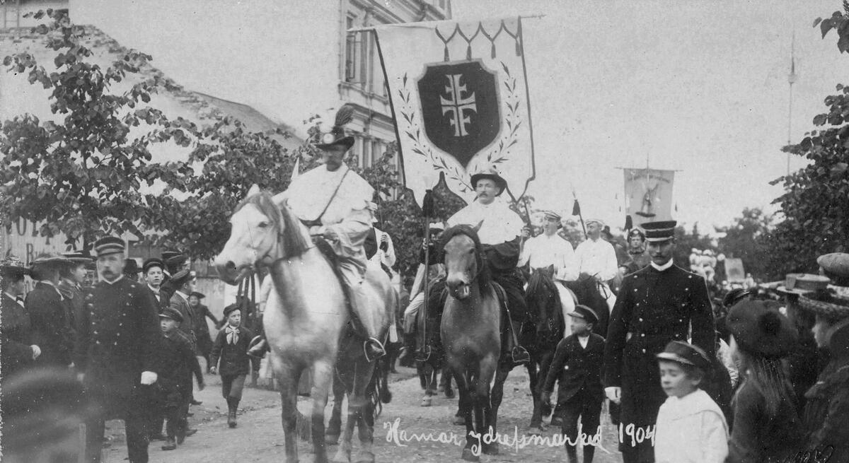 Postkort, Hamar, historisk opptog i 1904, Hamar Idrettsmarked, folk i kostymer på hest, fane, politi,
