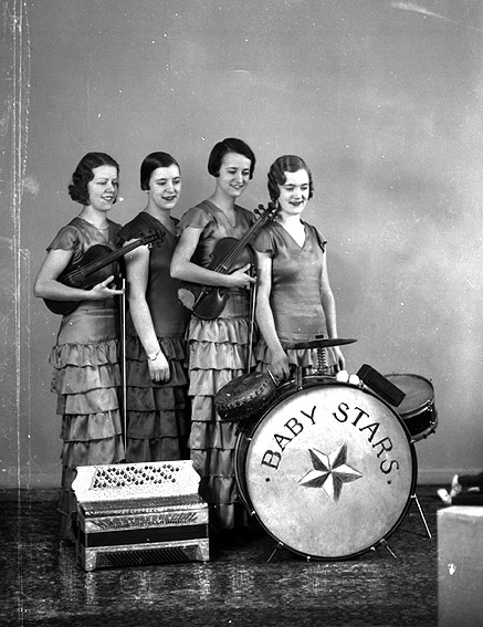 Fyra kvinnor med olika musikinstrument.
Fotografens ant:Baby Stars Orkester.