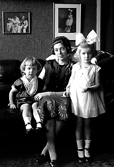 Kvinna och två barn i hemmiljö.