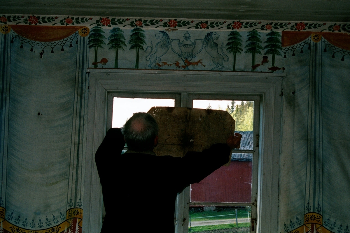 Leif Nyman står vid ett fönster på Bryggegården med en schablon som använts vid bemålandet av salen på Bryggegården. Schablonens mönster återfinnes över fönstret och föreställer två lejon med en urna mellan sig. 

Bryggegårdens dekor är målad av Anders Nilsson, även kallad Gammelmålaren. Typiskt för Anders Nilsson är hans fransar i vitt och svart på de målade draperingarna, detta för att måleriet skulle visa att salen skulle användas för både glädje och sorg.