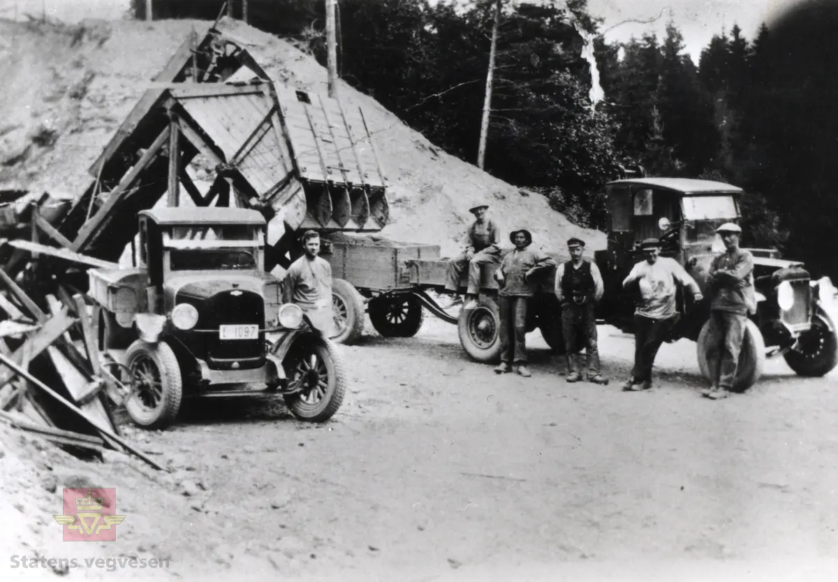 Grusframstilling på Hadeland i 1930-åra. Chevrolet lastebil med registreringsnummer E-1097 og Republic lastebil. 
Vegarbeidere er klare for oppdrag.