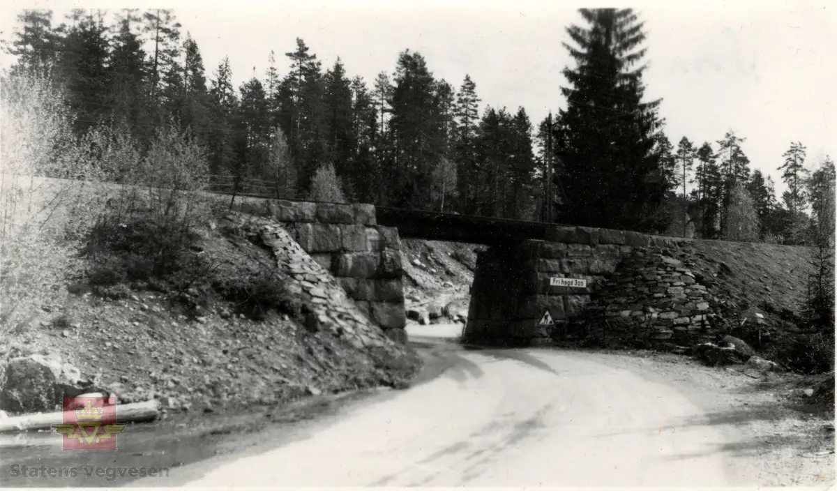 Stryken vegundergang 1954. Bildet viser vegen med undergang ved passering av jernbanelinja. Fri høgde 3,05 meter. I bakgrunnen er det skog. Undergangen er oppbygd av  i stein, tørrmur.