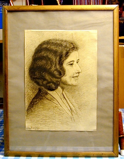 Portrett av ung kvinne med mørkt, halvlangt (bølget) hår. I profil.