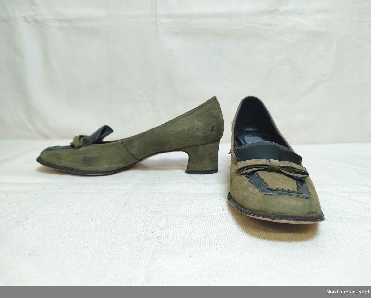 Grønne sko til dame i ssemsket skinn. Noen detaljer i grønn lakk. Sløyfe i front. Noe høyde på hæl. I skoeske som trolig ikke er original.
