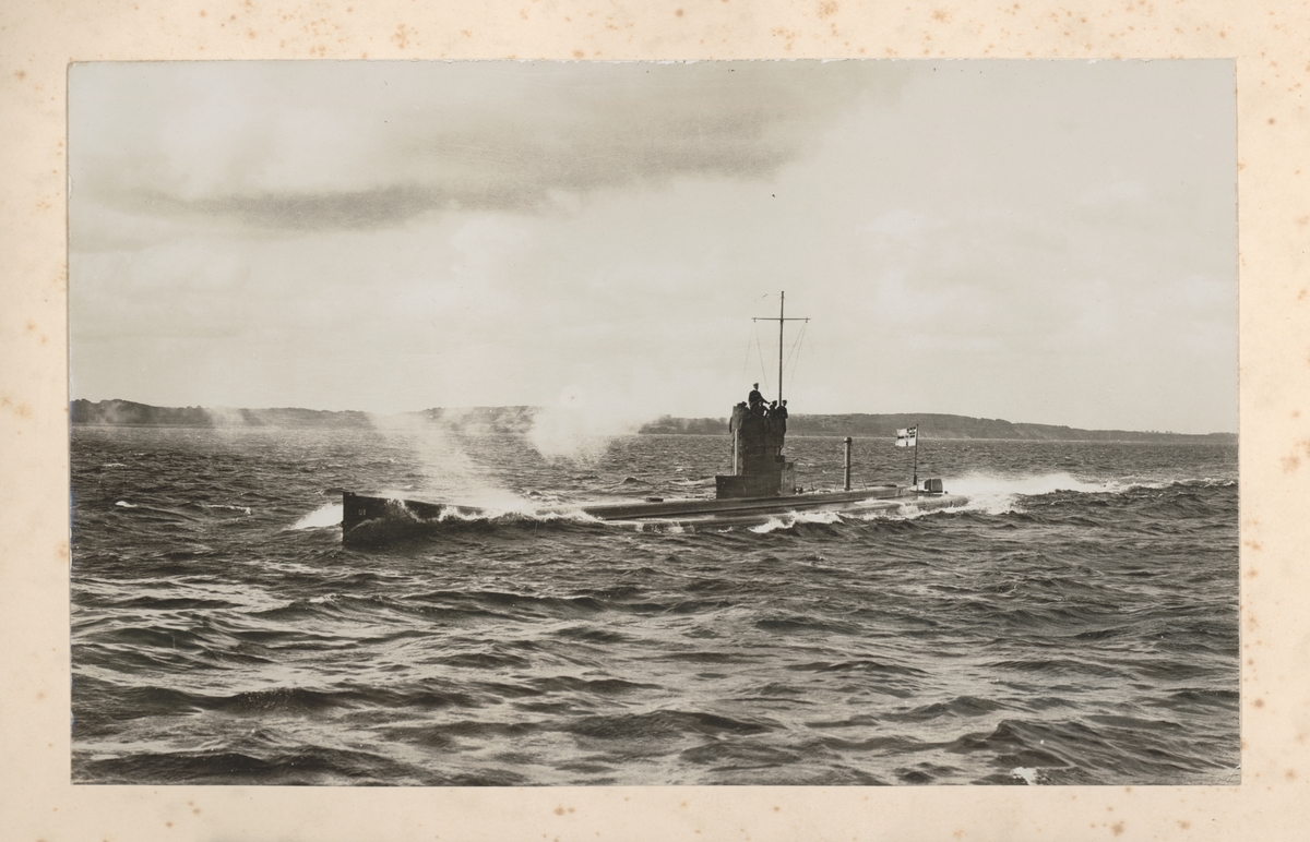 Bilden visar den tyska ubåten U 9 under Första världskrig till havs. I bak har den hissat den tyska krigsflaggan "Reichskriegsflagge".