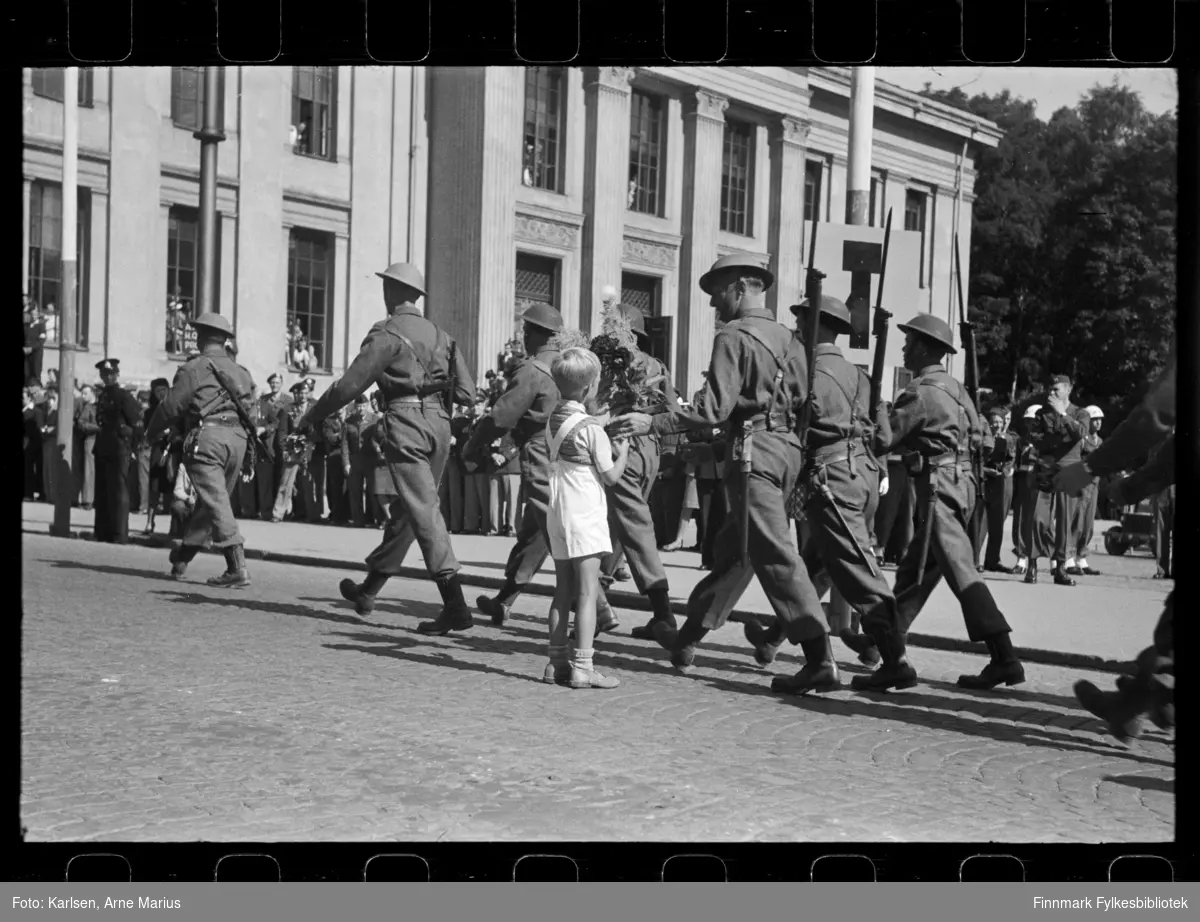 Britiske soldater marsjerer i parade på de alliertes dag den 30. juni 1945 (The Allied Forces day)

En gutt rekker en soldat blomster i det paraden går forbi 
