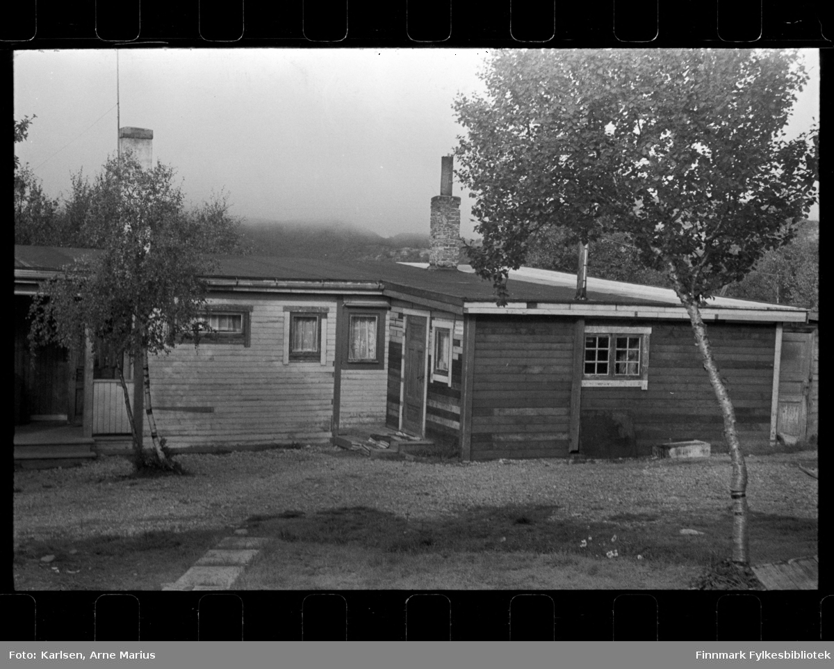Foto av ukjent hus, antagelig i Finnmark

På veggen av huset kan man se et skilt der det står: Pengelotteriets Kommisjonær (synes bedre på foto Fbib.93112-436)

Foto trolig tatt på slutten av 1940-tallet, tidlig 1950-tallet