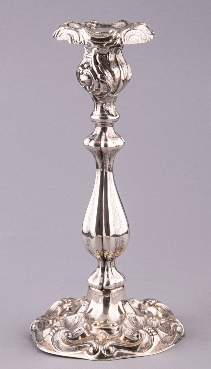 Ljusstake, tillhör ett par, av silver, i nyrokoko, pressad och ciselerad dekor.