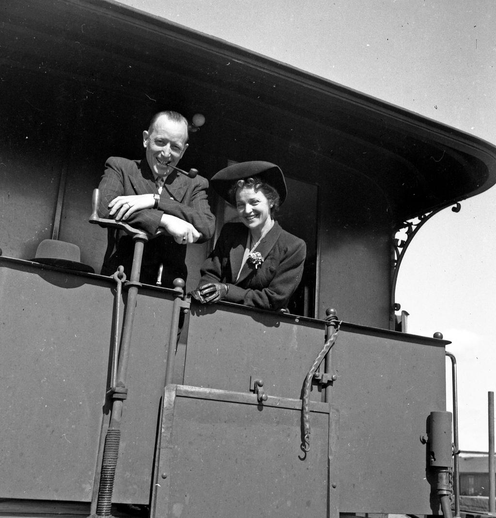 En man och en kvinna ståendes i ett tåg.